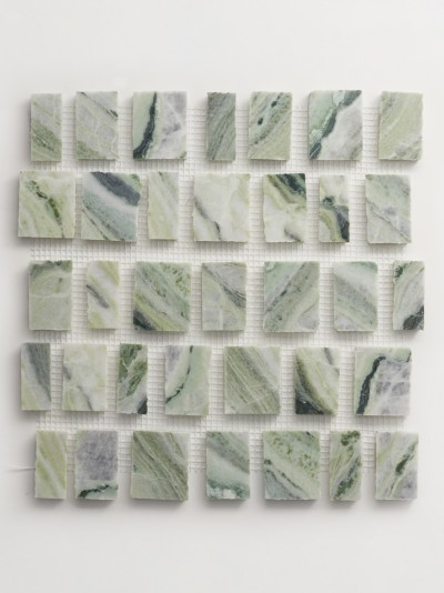 a piece of green marble on a white surface.