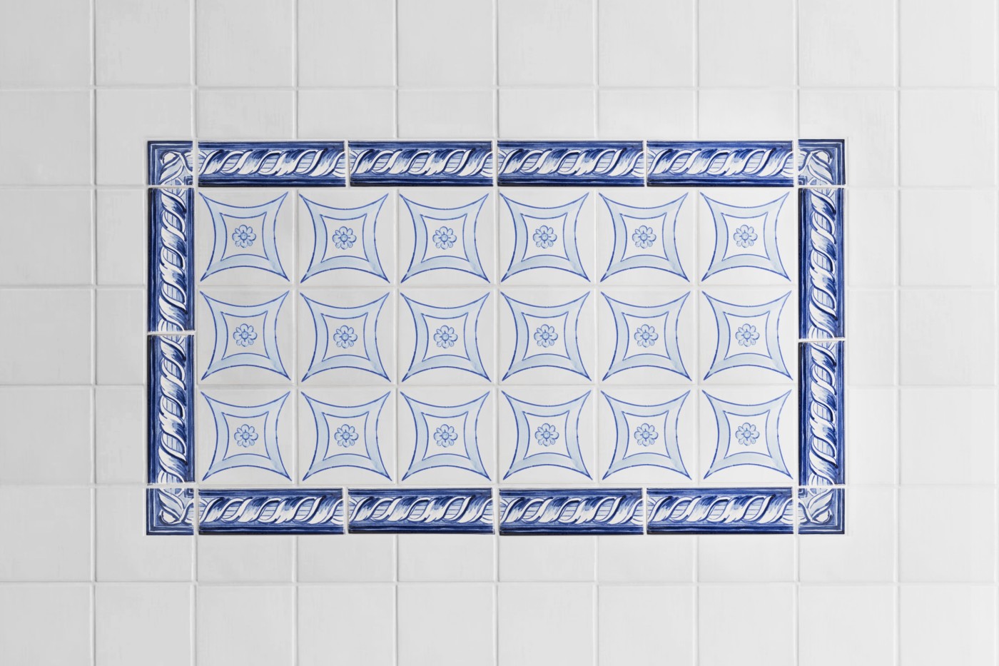 a blue and white tiled design in a bathroom.