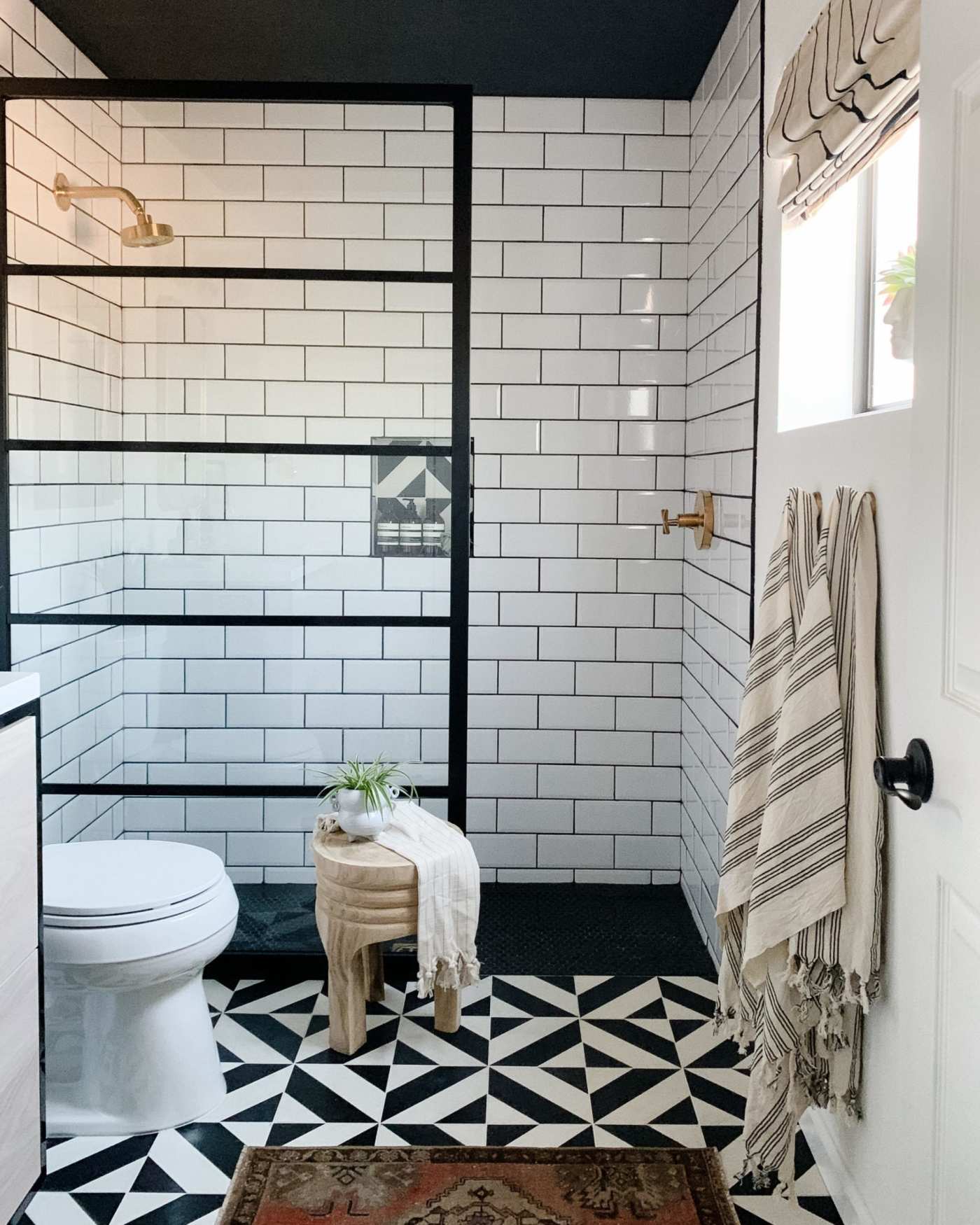 a black and white bathroom with a tiled floor.