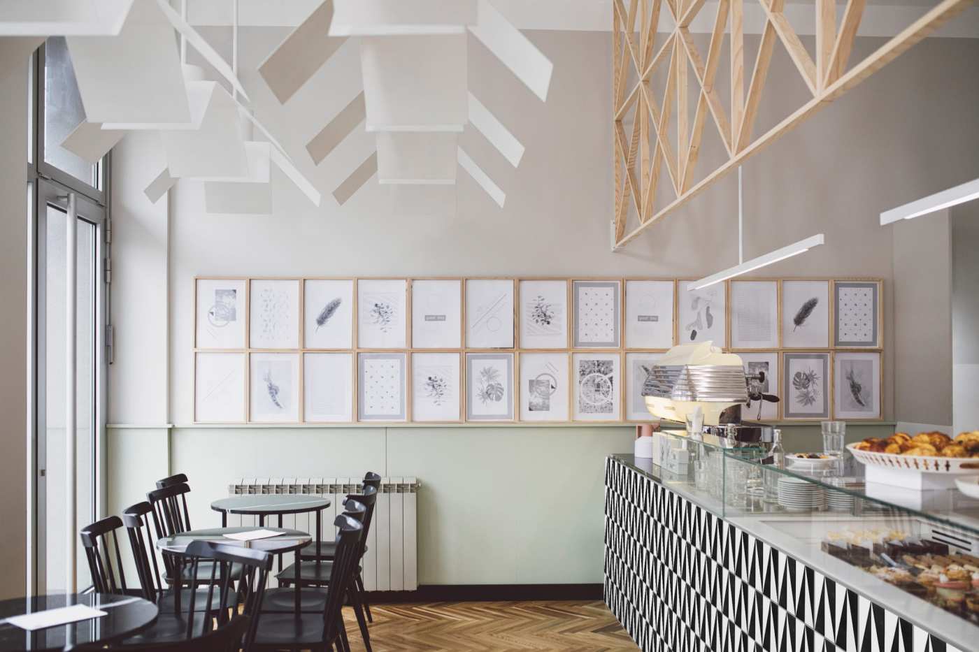 the interior of a cafe with wooden tables and chairs.