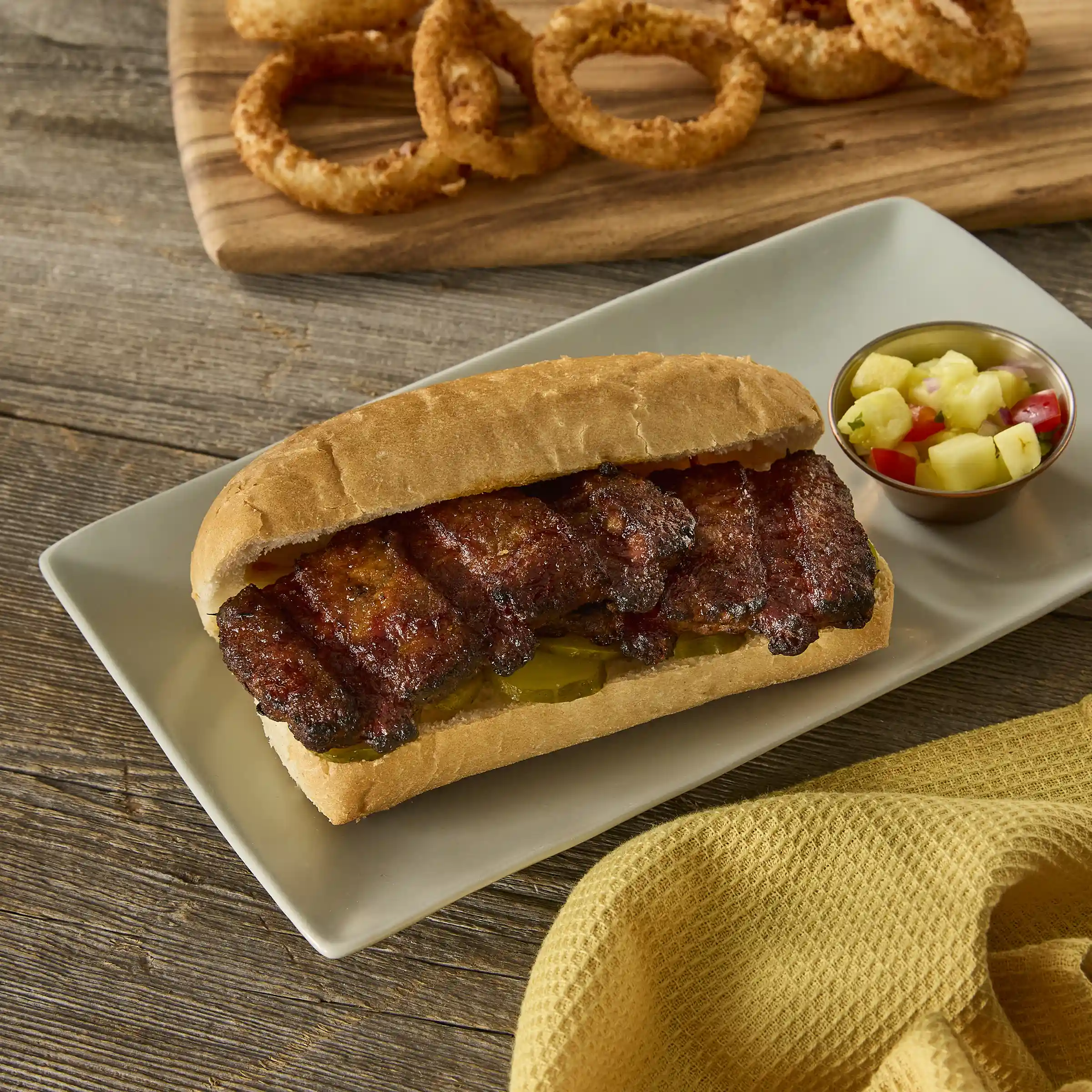 AdvancePierre™ Fully Cooked, Flamebroiled, Boneless Rib Shaped Pork Patties Topped with BBQ Sauce_image_1