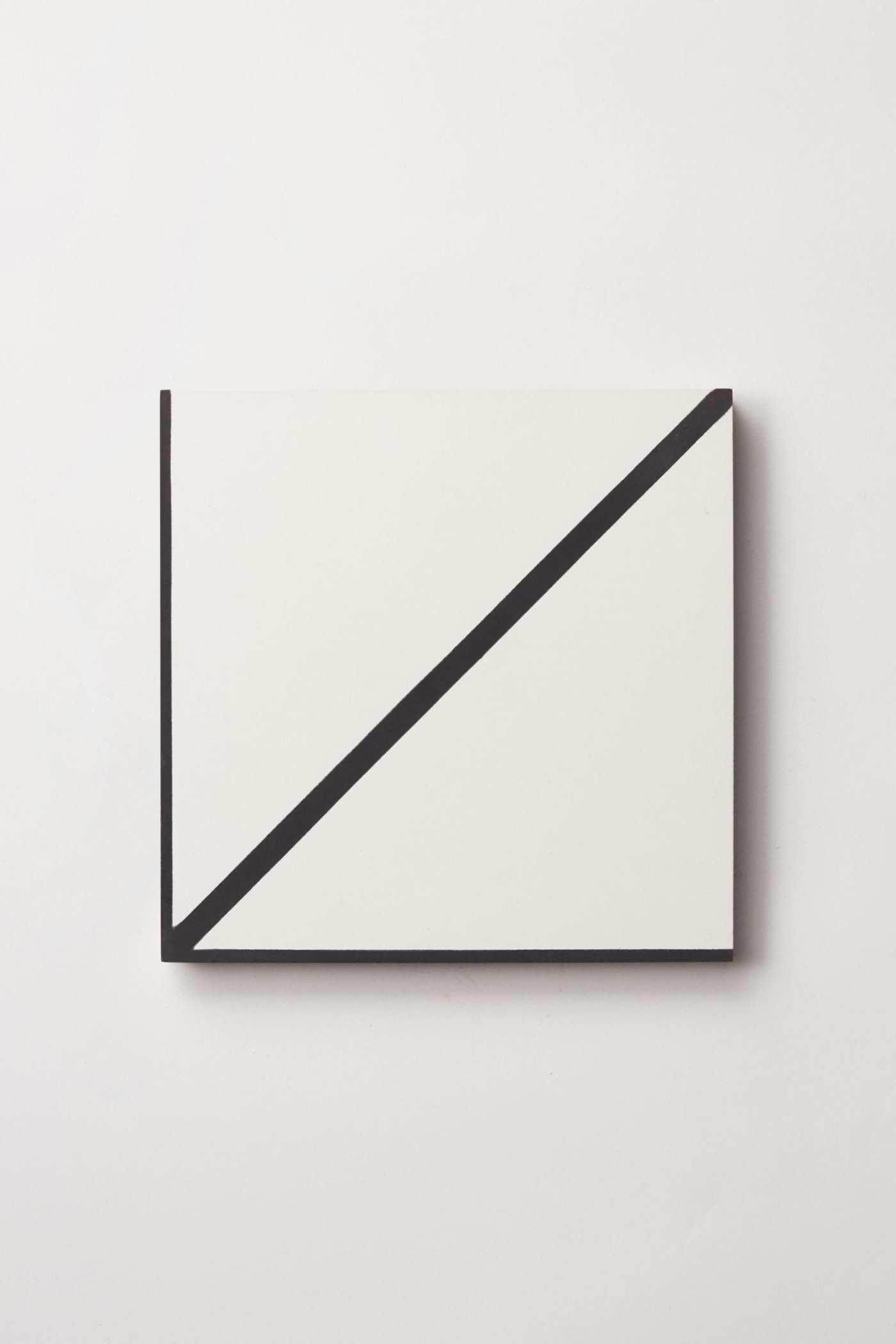 a white tile with a diagonal black line on it.