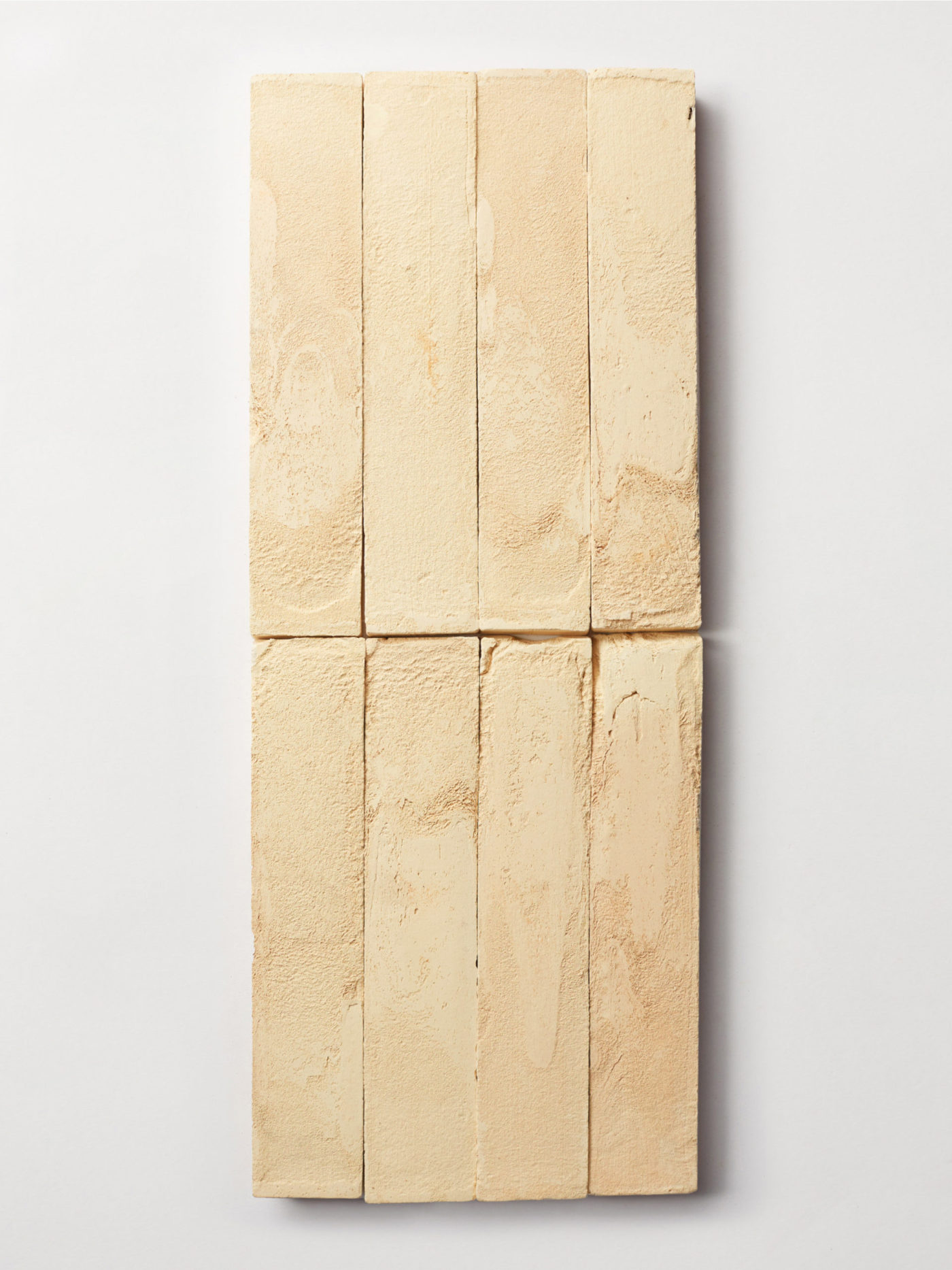 a group of rectangular beige tiles on a white surface.