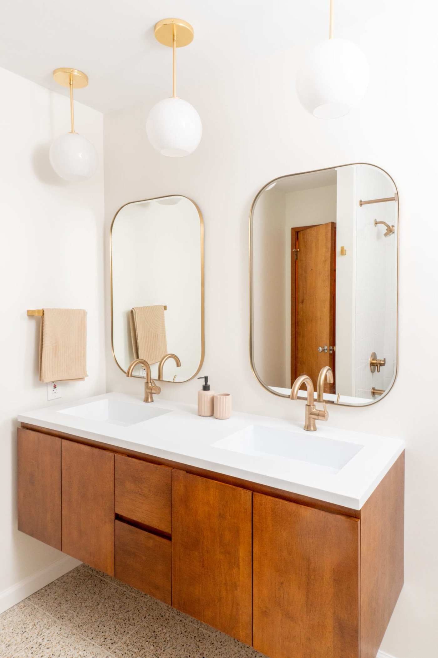 a bathroom with two sinks and two mirrors.