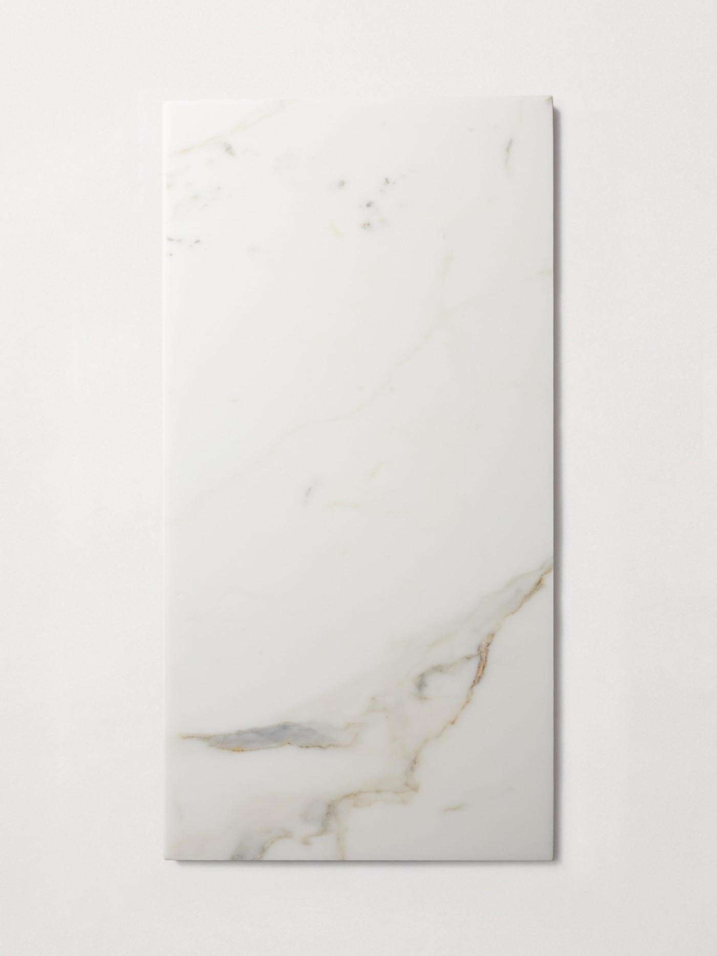 a white rectangular marble tile on a white surface.