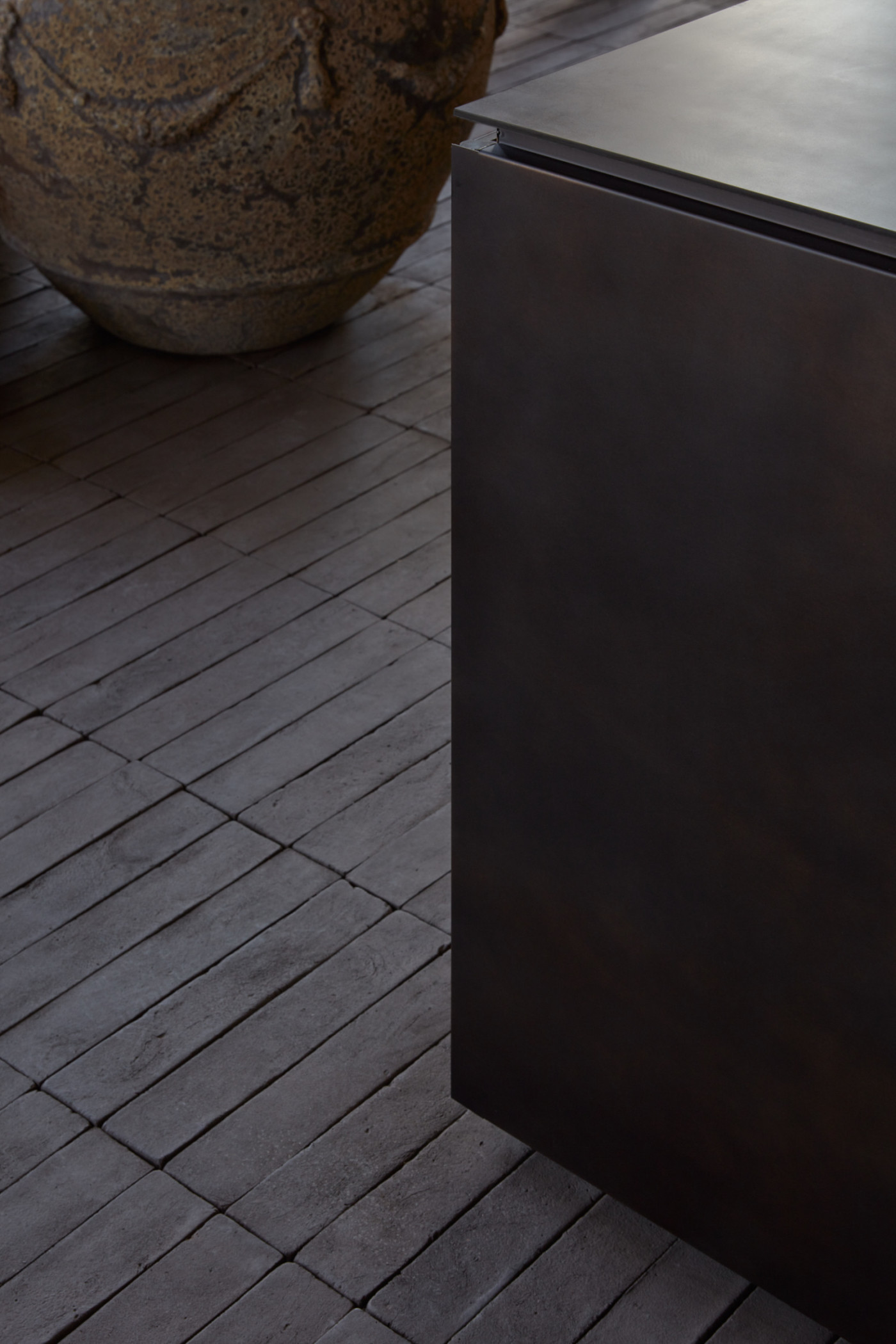 a black box sitting on a dark tiled floor.