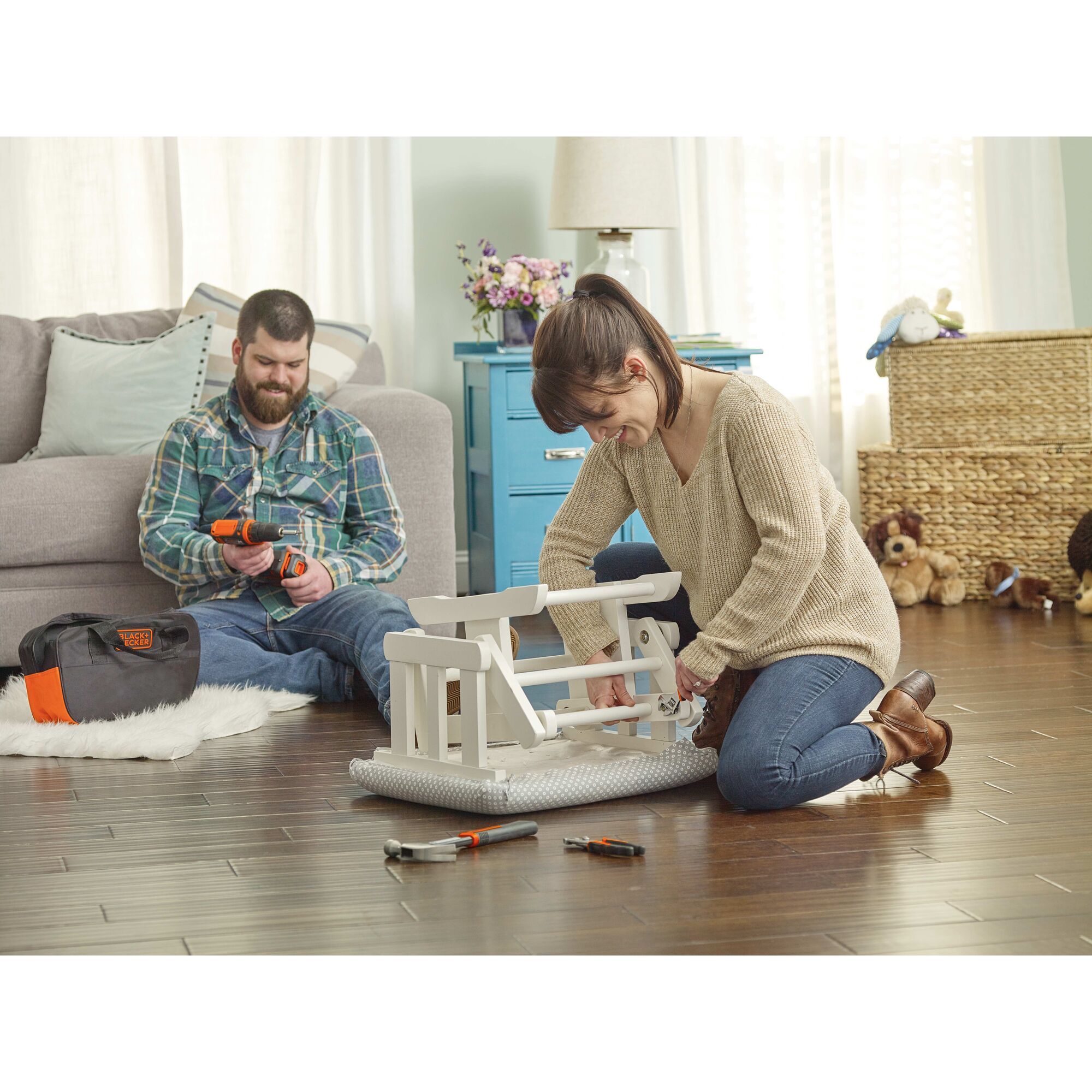 Woman assembling an ottoman with the contents of the BLACK+DECKER Home Tool Kit
