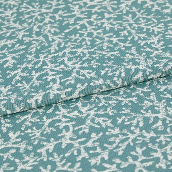 Woven teal upholstery fabric with irregular white abstract print; folded along a seam, lying flat; close-up studio view showing texture and weave.