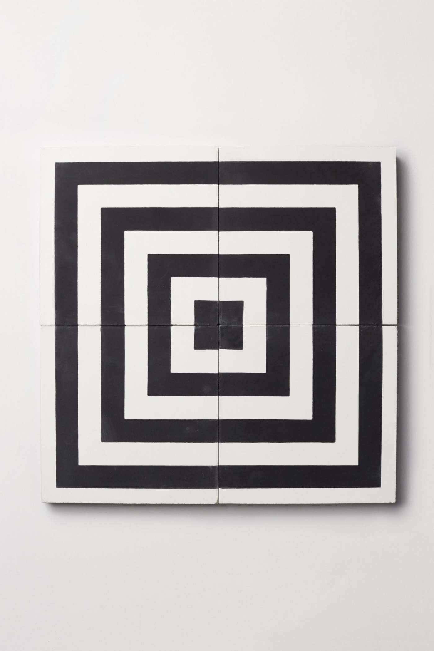 four black and white tiles on a white surface.