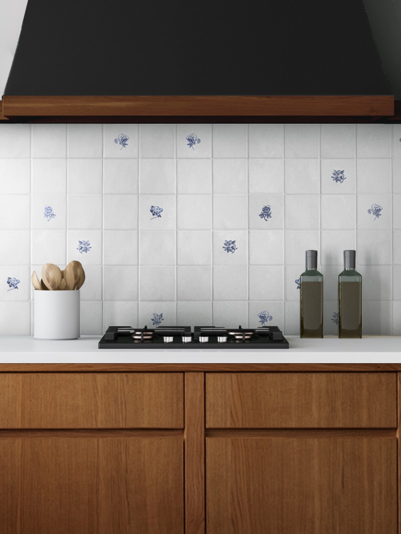 a blue and white tiled stove backsplash in a kitchen with wooden cabinets.