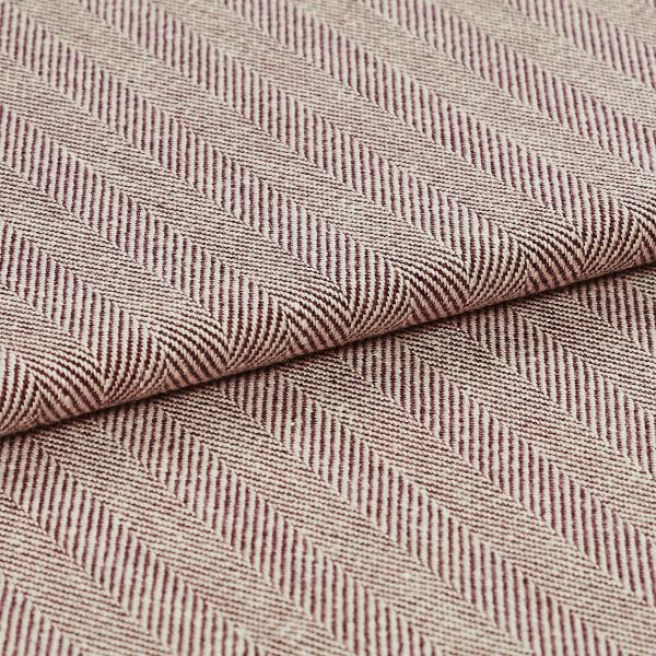Woven upholstery fabric with beige-and-burgundy diagonal herringbone stripes and ribbed texture; folded and overlapped to reveal the pattern repeat; close-up, evenly lit studio setting.