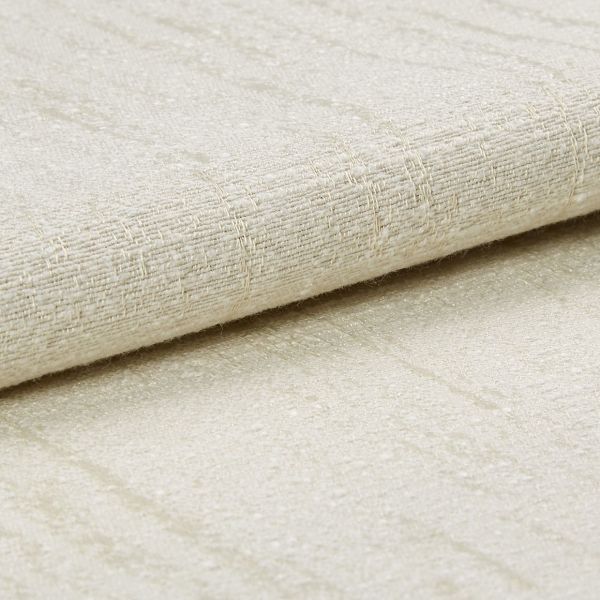 A folded beige woven fabric with subtle sheen and raised grid texture, layered over matching fabric; close-up studio view with soft, diffuse lighting on a neutral surface.