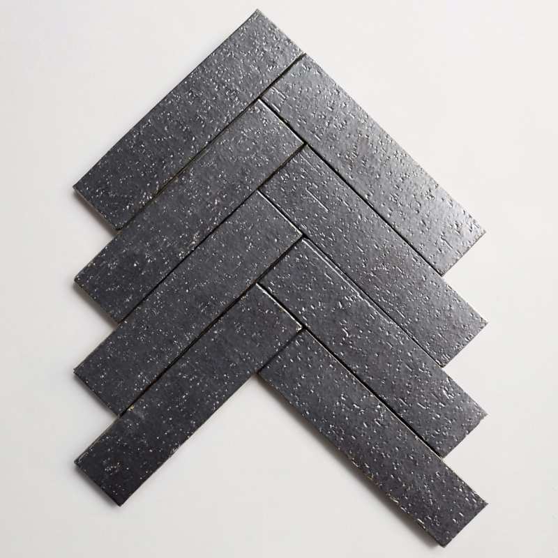a black herringbone tile on a white background.