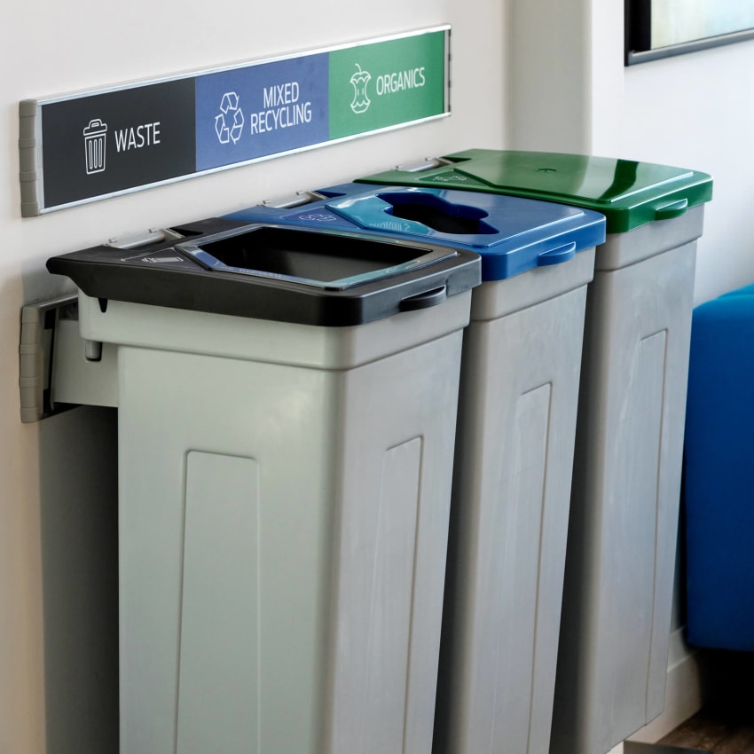 triple waste and recycling station with grey bodies with colored lids and effective signs and labels