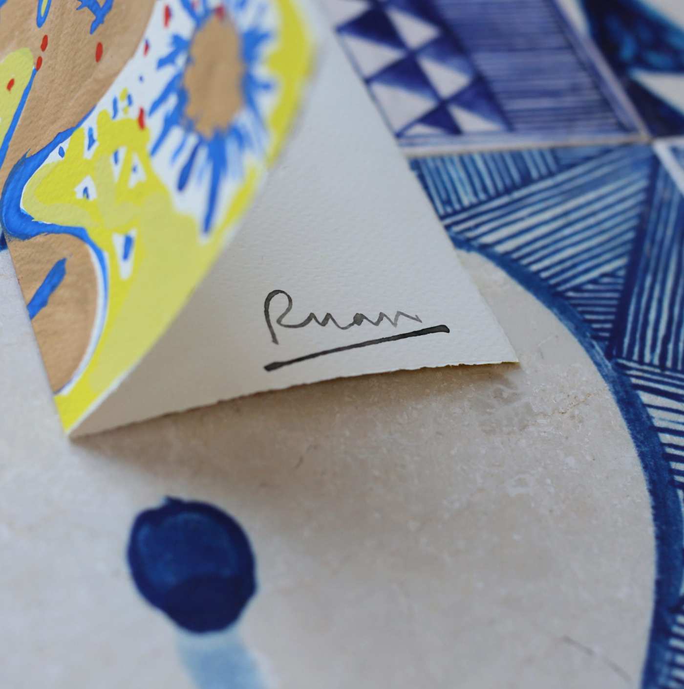 a paper card with a handwritten note on a piece of patterned tile.