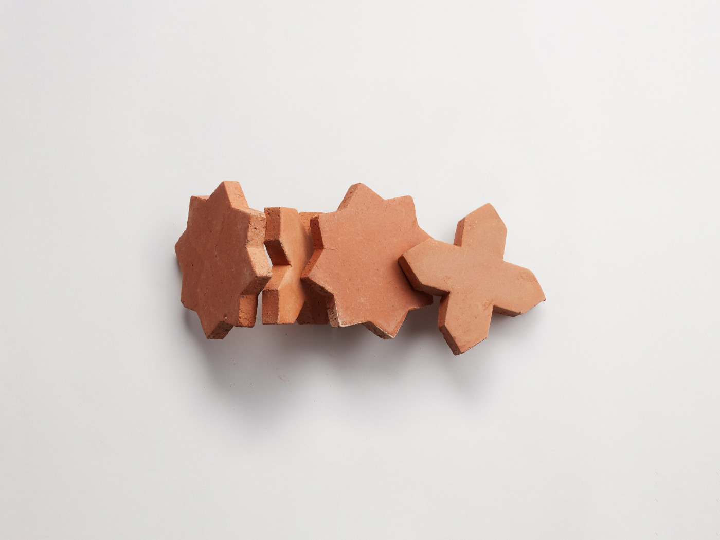 a group of red clay pieces on a white surface.