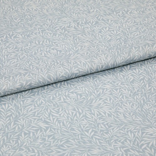 Light-blue printed fabric with a white leaf motif folded once and overlapping; close-up of a soft woven textile surface under even, neutral lighting.