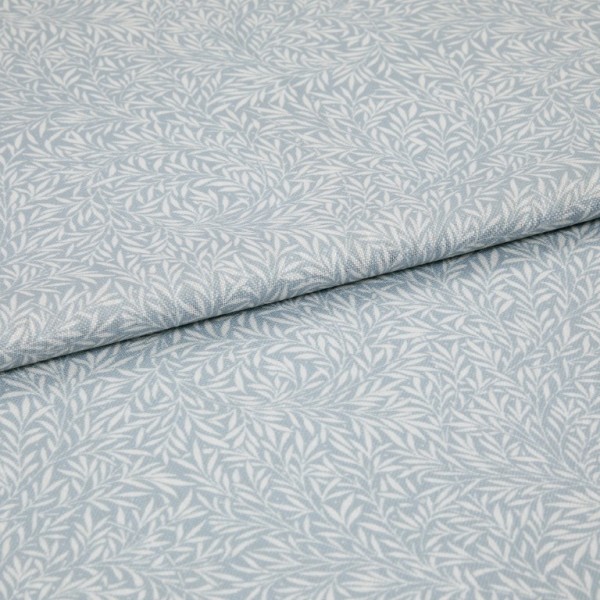 Light-blue printed fabric with a white leaf motif folded once and overlapping; close-up of a soft woven textile surface under even, neutral lighting.