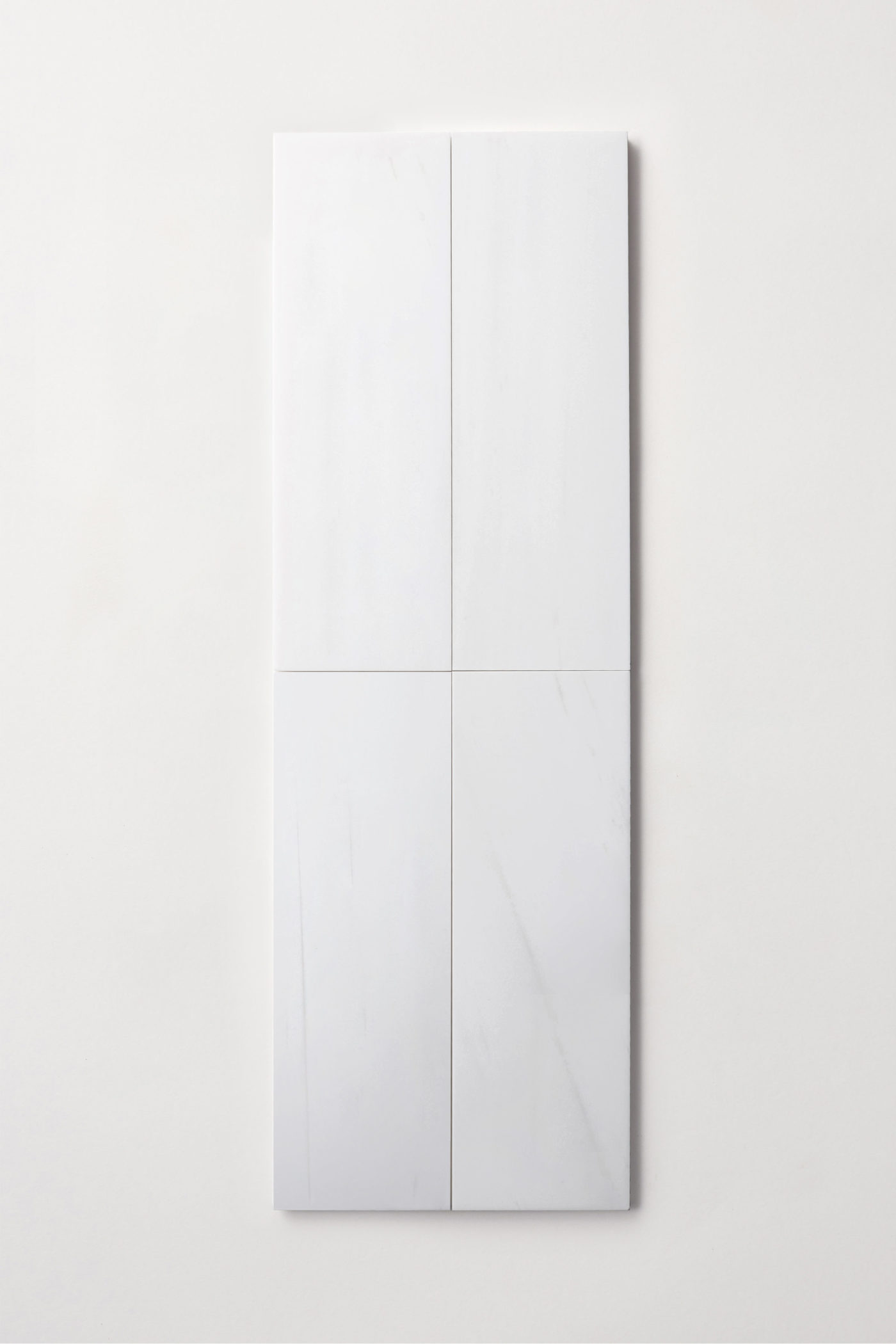 four white rectangle tiles on a white surface.