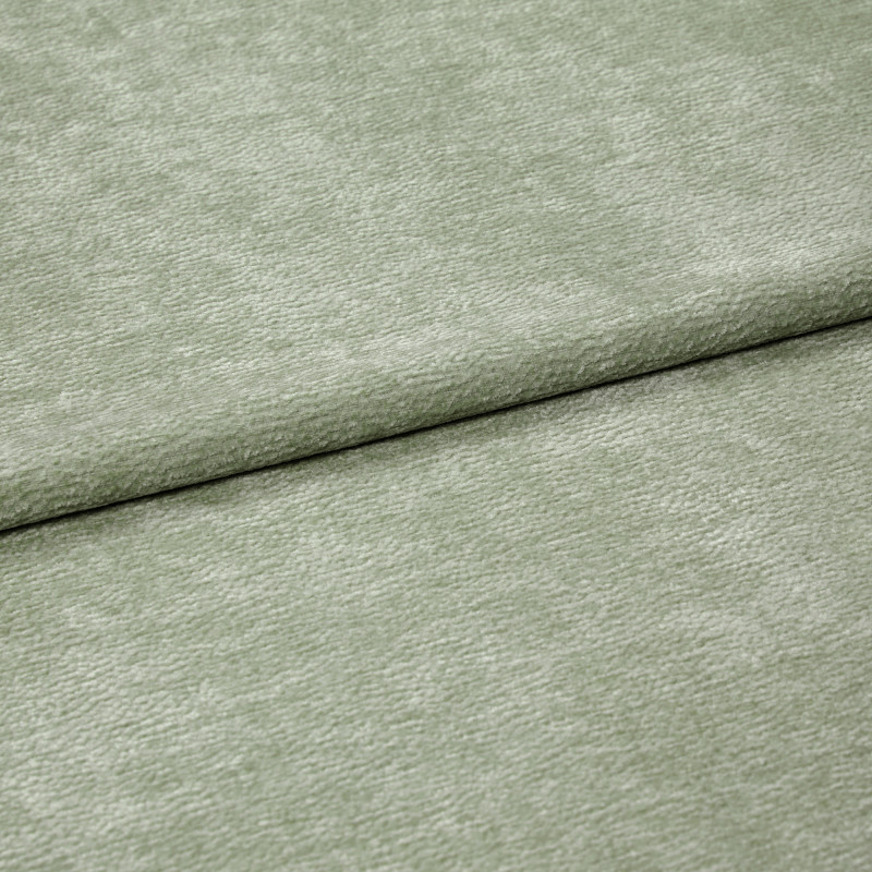 Velvet-like pale sage-green fabric folded horizontally, creating an overlapping seam; soft, short-pile texture; close-up, evenly lit studio view filling the frame.