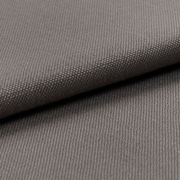Gray woven fabric (canvas-like), folded diagonally over itself, showing dense pebble and twill textures; soft, even studio lighting highlights fine weave in a close-up, neutral setting.
