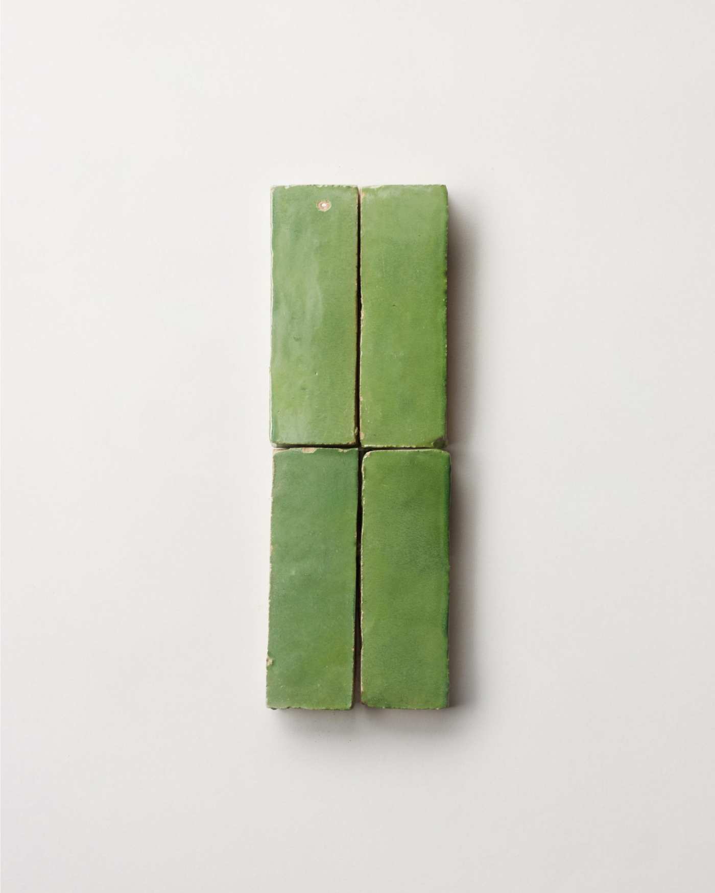 a set of green tiles on a white surface.