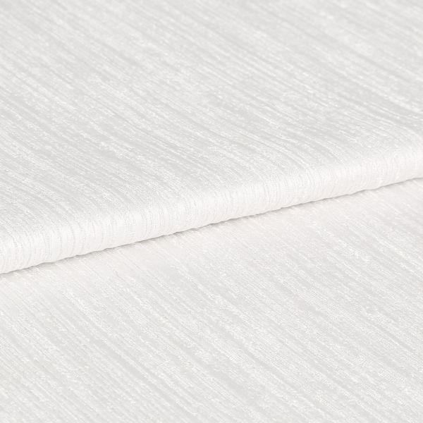 White ribbed textured fabric, folded in overlapping layers showing subtle horizontal sheen; lying stacked on itself, photographed in close-up under soft, even studio lighting with a neutral background.