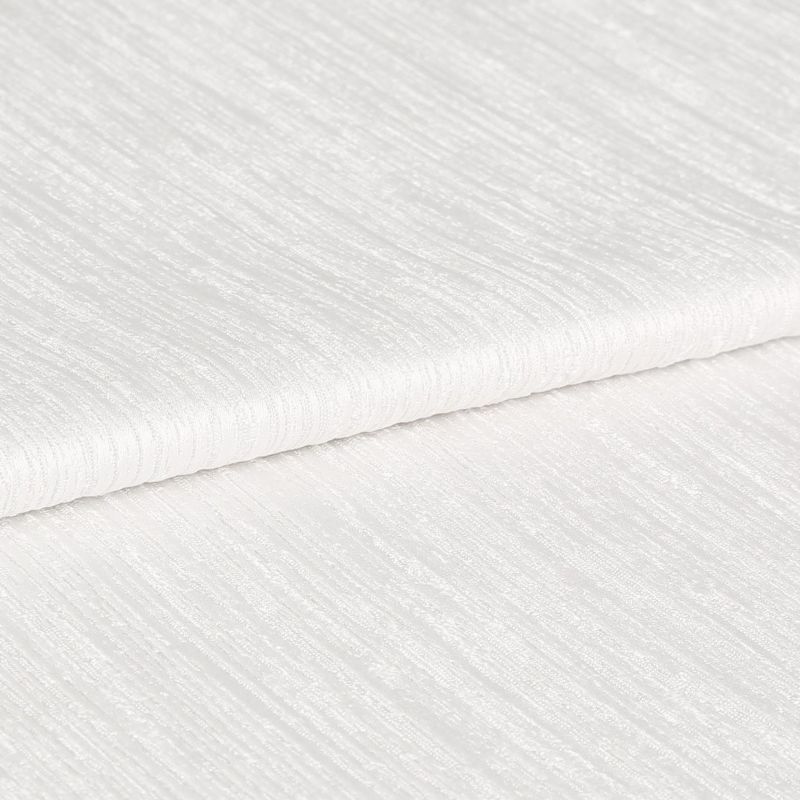 White ribbed textured fabric, folded in overlapping layers showing subtle horizontal sheen; lying stacked on itself, photographed in close-up under soft, even studio lighting with a neutral background.