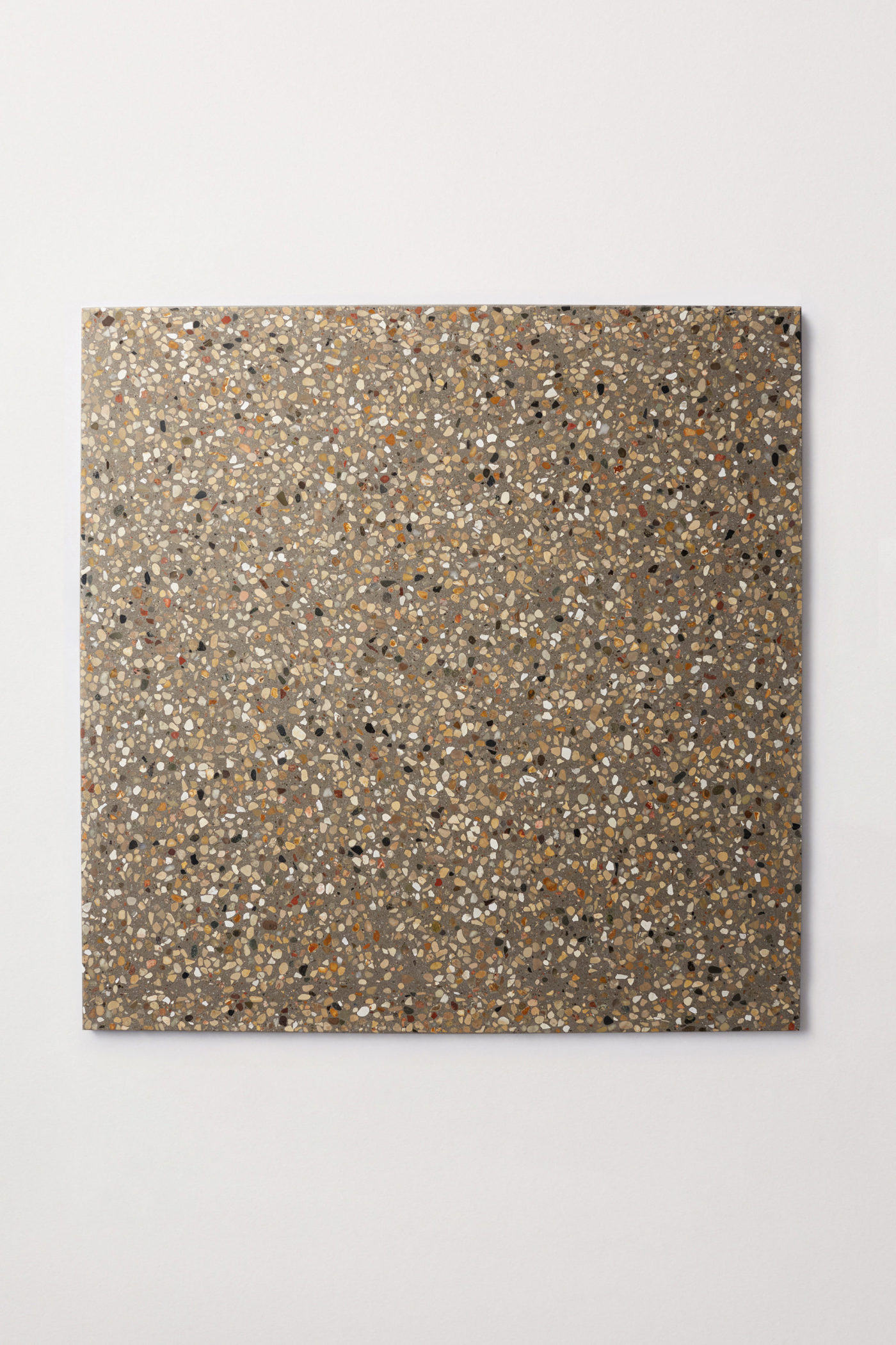 a square grey tile with a terrazzo pattern on it.