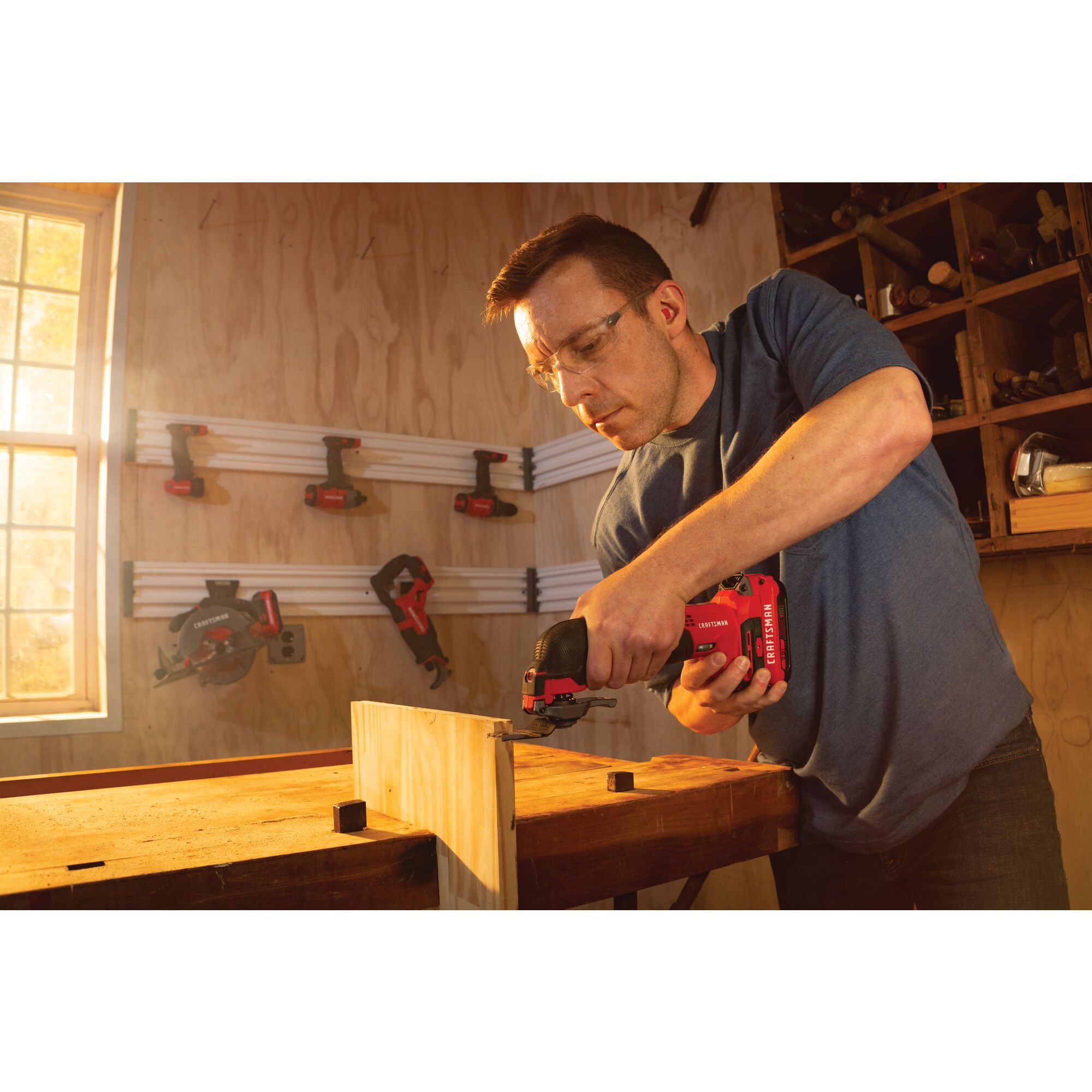 Cordless oscillating tool kit being used on wooden plank.
