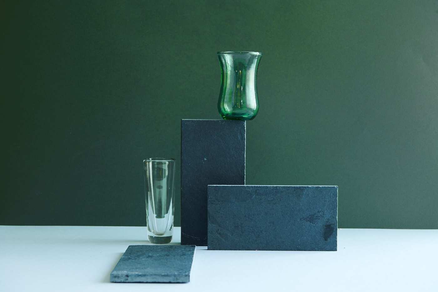 a set of slate tiles and two glasses on a table.