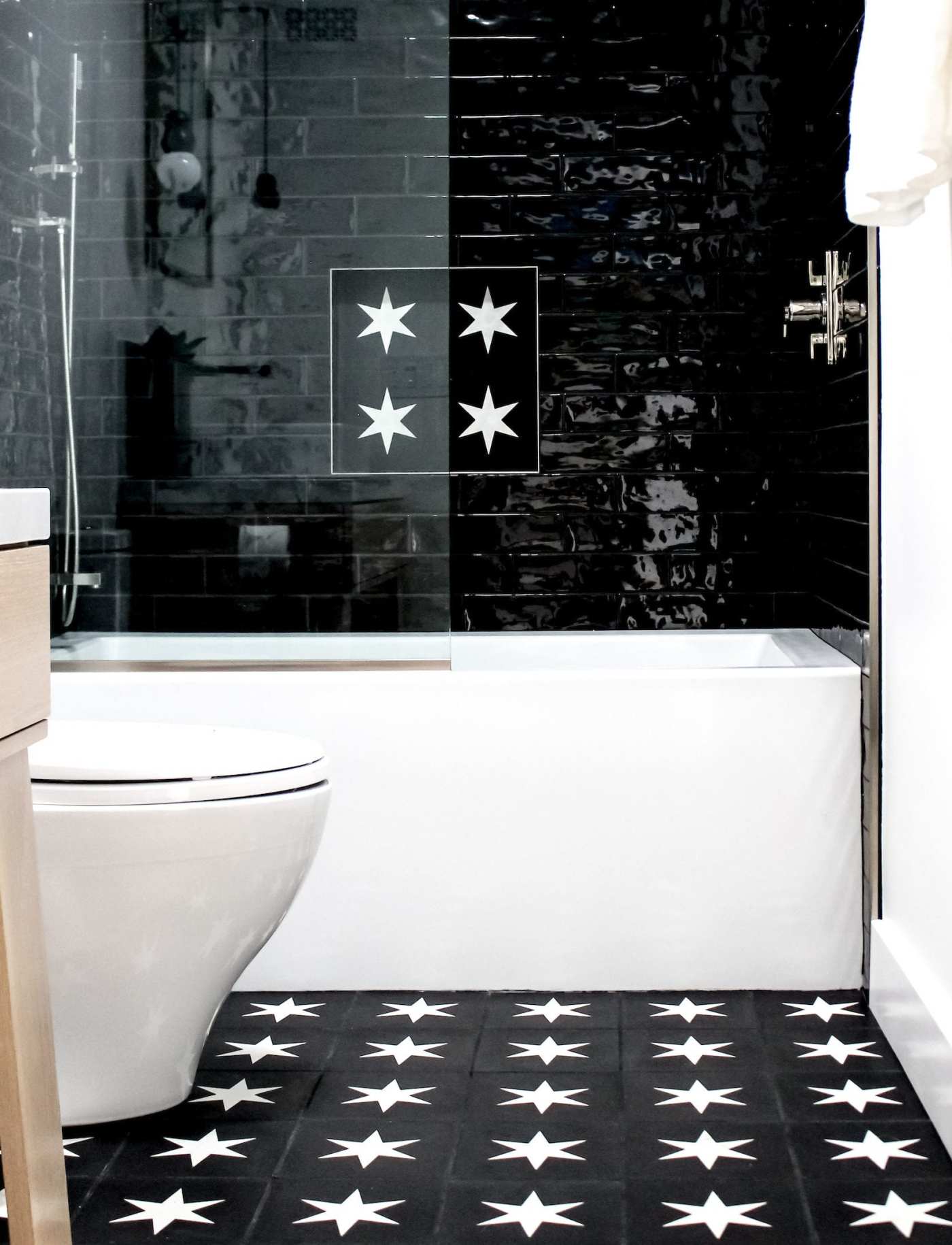 a bathroom with black and white tiled floor with star designs.