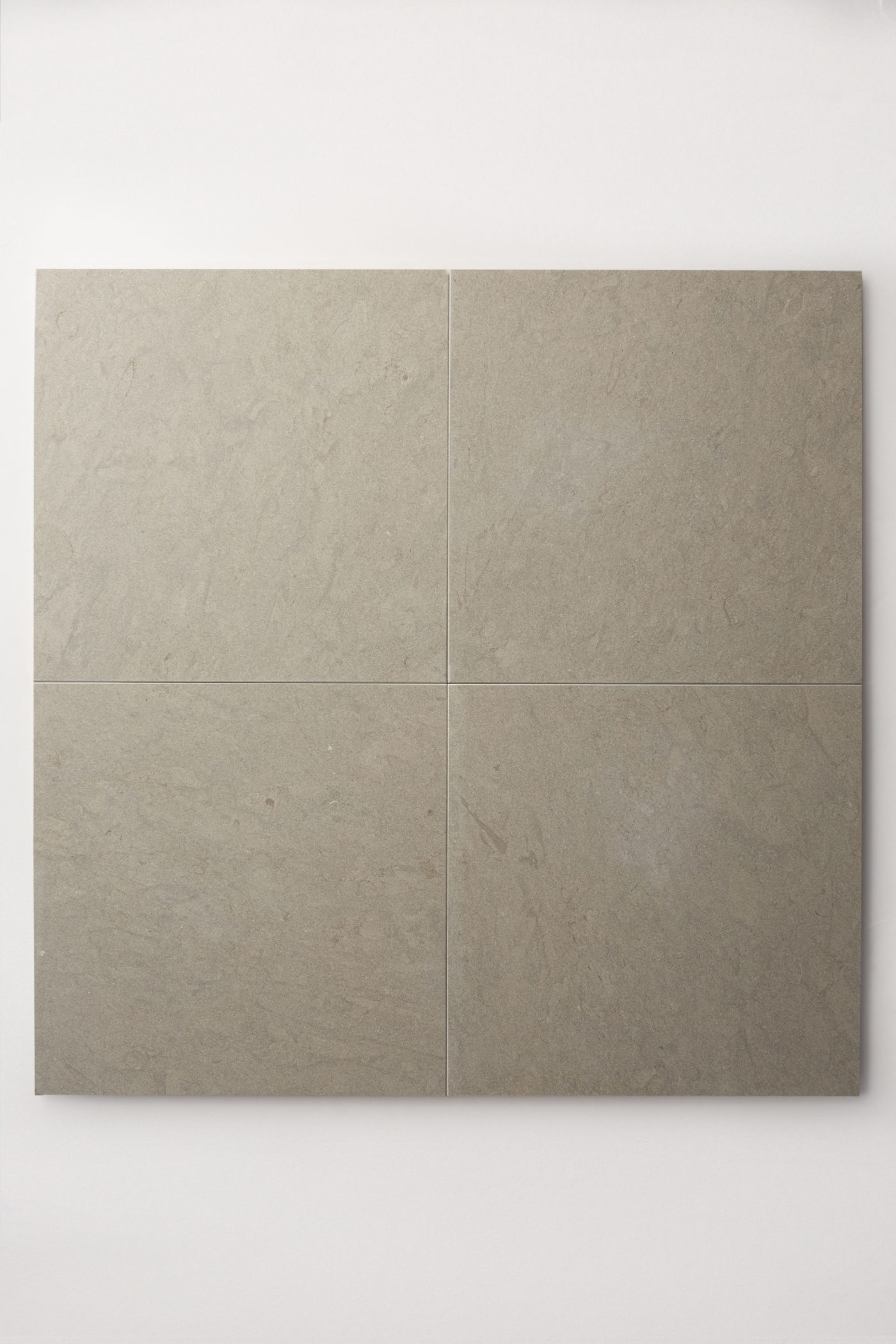 four square grey limestone tiles on a white surface.