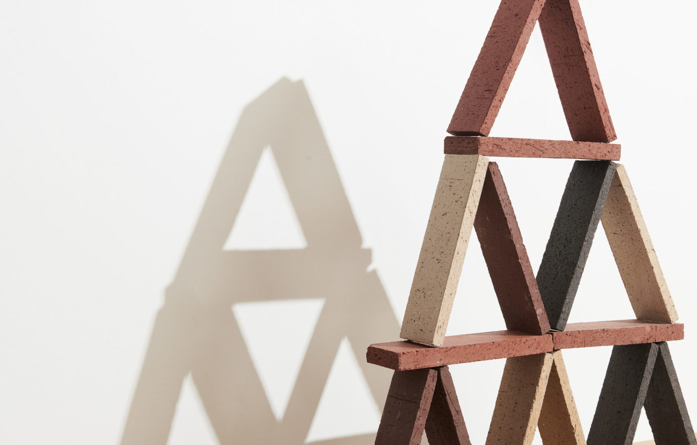 a set of various colored bricks stack like a house of cards.