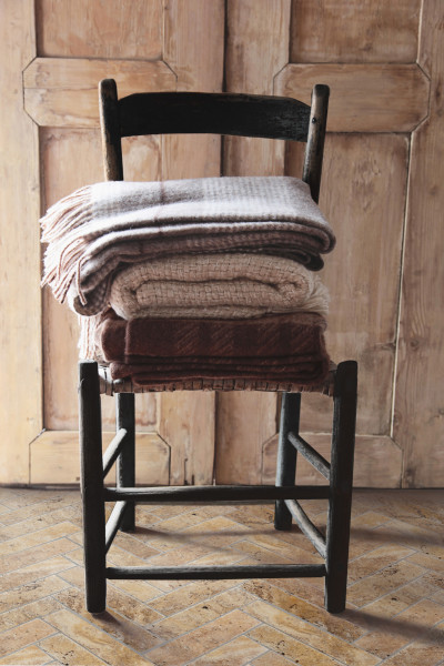 a stack of blankets on a wooden chair.