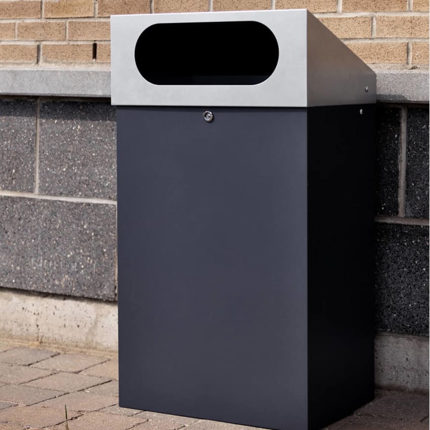 durable powder coated steel outdoor trash bin with locking lid and large waste opening outside a shopping plaza