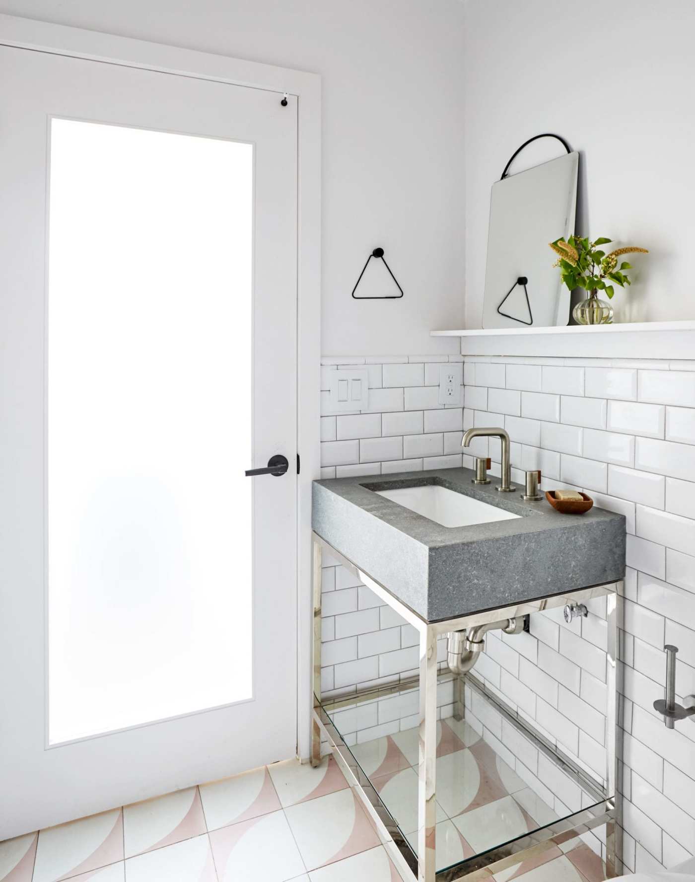 a white bathroom with a sink and a door.