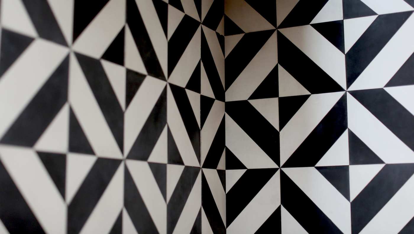 a tiled wall with a black and white geometric pattern.