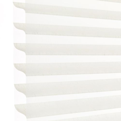 White horizontal pleated cellular blind with scalloped edges, fully lowered and closed, filtering bright daylight; close-up view showing soft shadowed ridges against a pale background.
