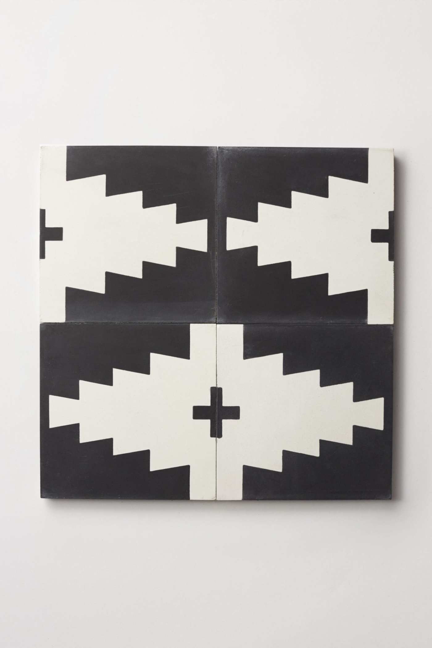 four black and white tiles creating a pattern on a white surface.