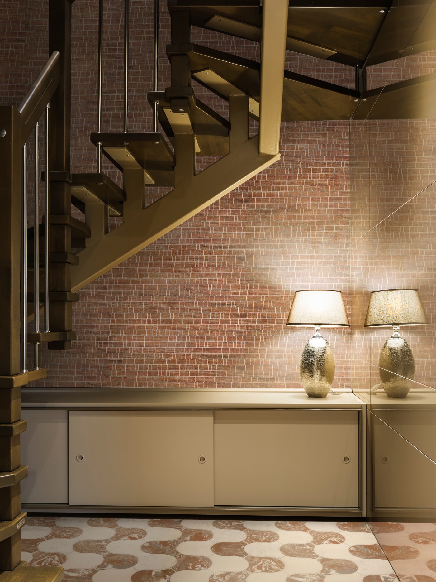 a staircase in a room with a lamp and tiled floor and wall.