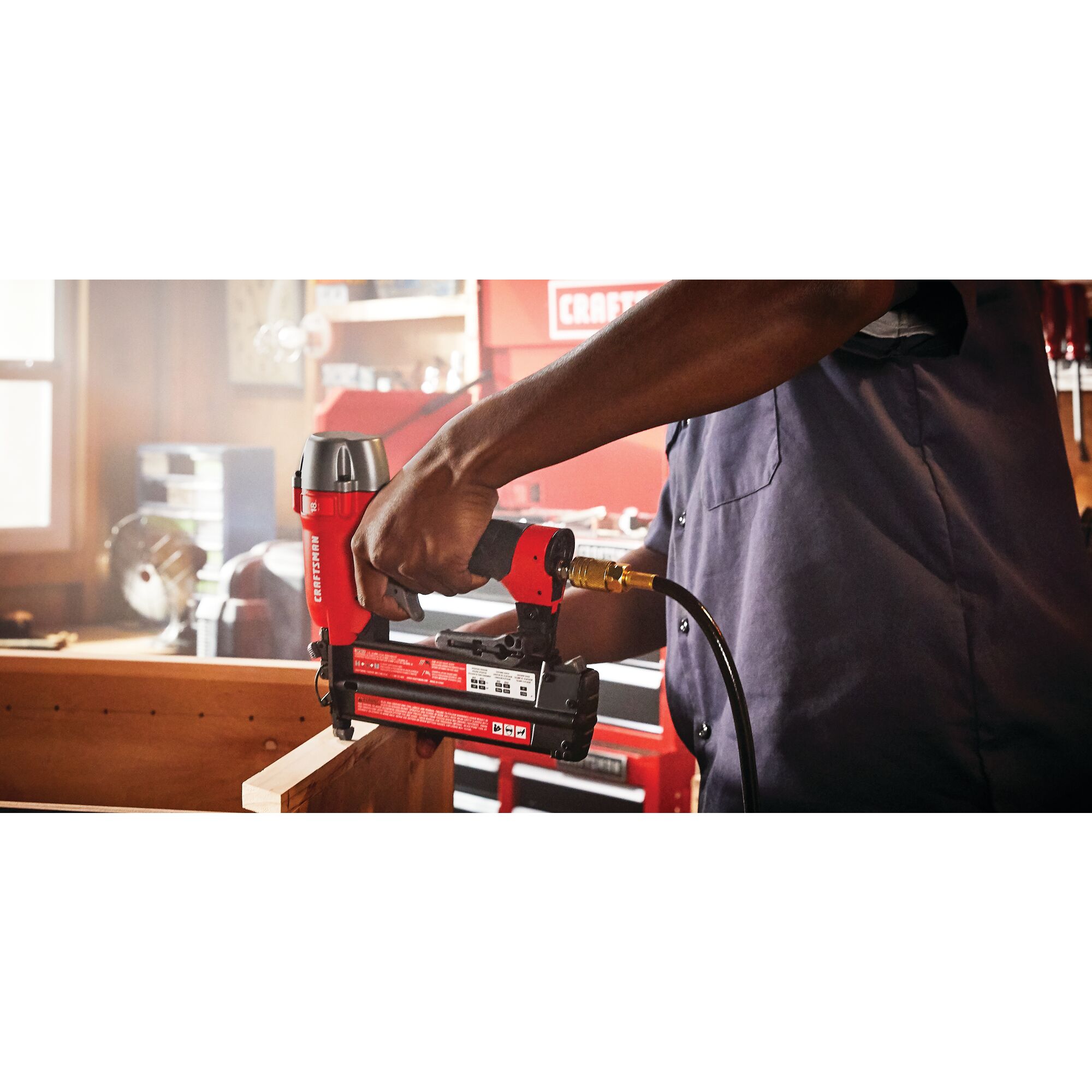 18 gauge brad nailer being used to nail a wooden strip by a person.