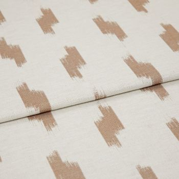 Cream woven fabric with repeating irregular tan brushstroke rectangles (patterned), folded once and showing texture and seam; close-up textile sample under soft, even lighting on a neutral background.
