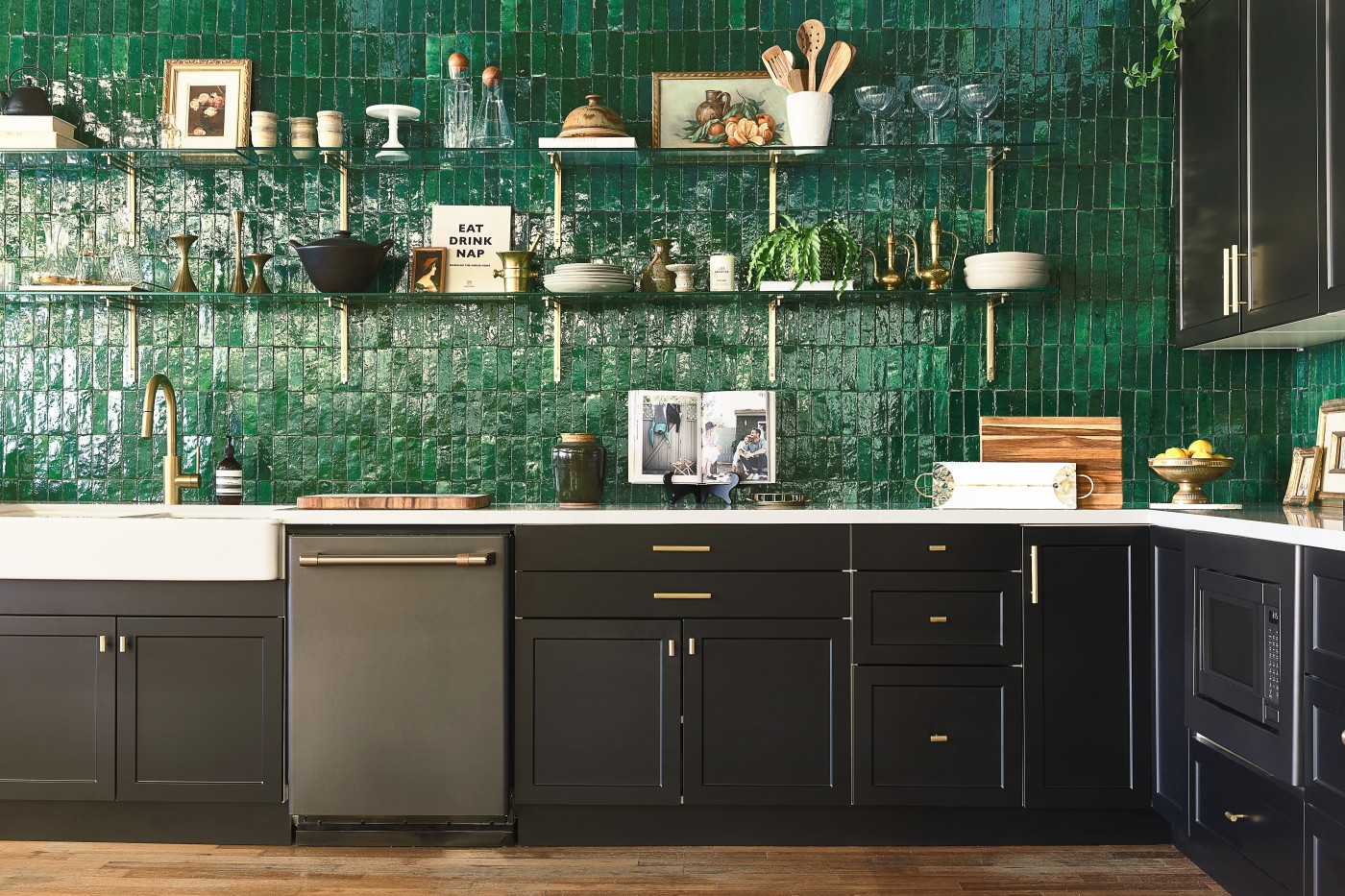 a kitchen with green tile and black cabinets.