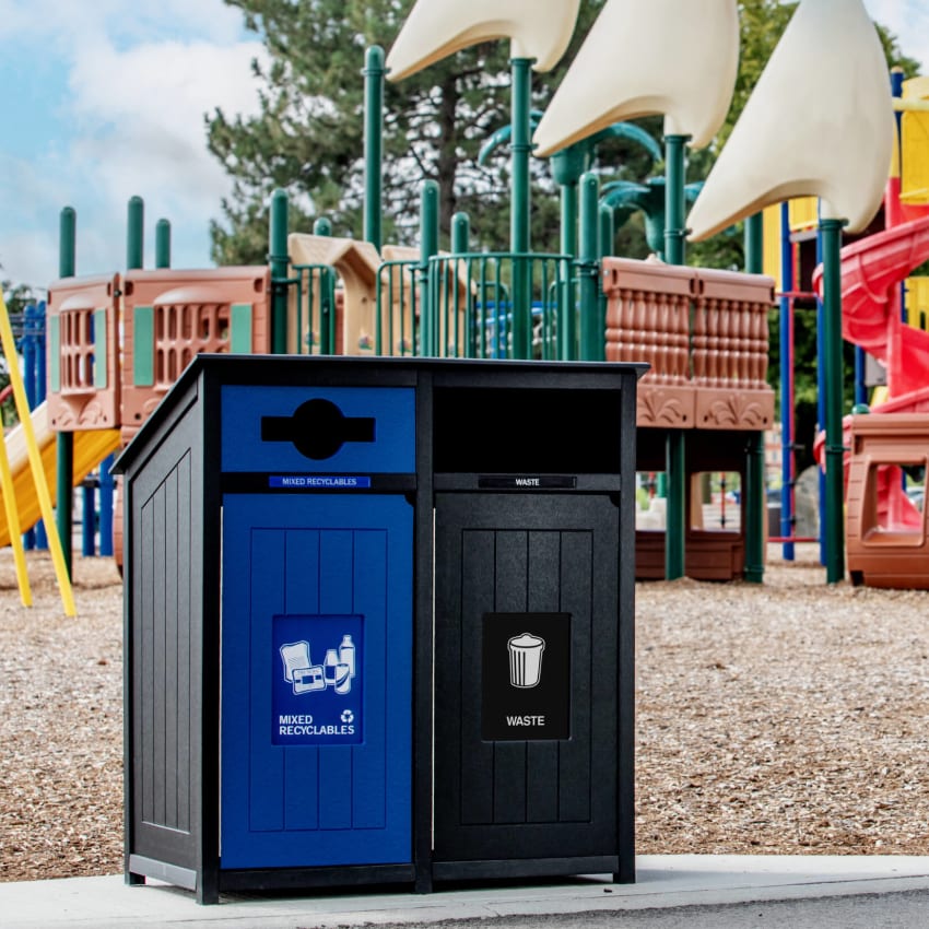 black and blue waste and recycling container at a playground