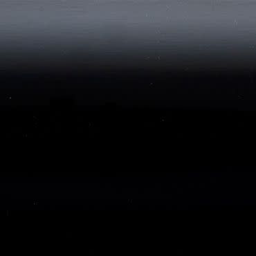 Horizontal dark gradient panel (object) showing faint horizontal banding and tiny light specks, appearing smooth and slightly reflective (action); occupying the entire frame in an abstract, low-light scene (context).