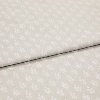 Beige cotton fabric with small white leaf motif, folded once to reveal overlapping layers; lying flat on a neutral surface under soft, even studio lighting for a close-up textile display.