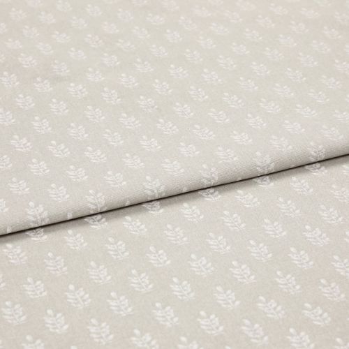 Beige cotton fabric with small white leaf motif, folded once to reveal overlapping layers; lying flat on a neutral surface under soft, even studio lighting for a close-up textile display.