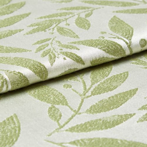 Folded jacquard fabric with raised pale-green leaf pattern on a cream background; fabric overlaps and rests, shown in a close-up view with soft directional lighting revealing its texture.