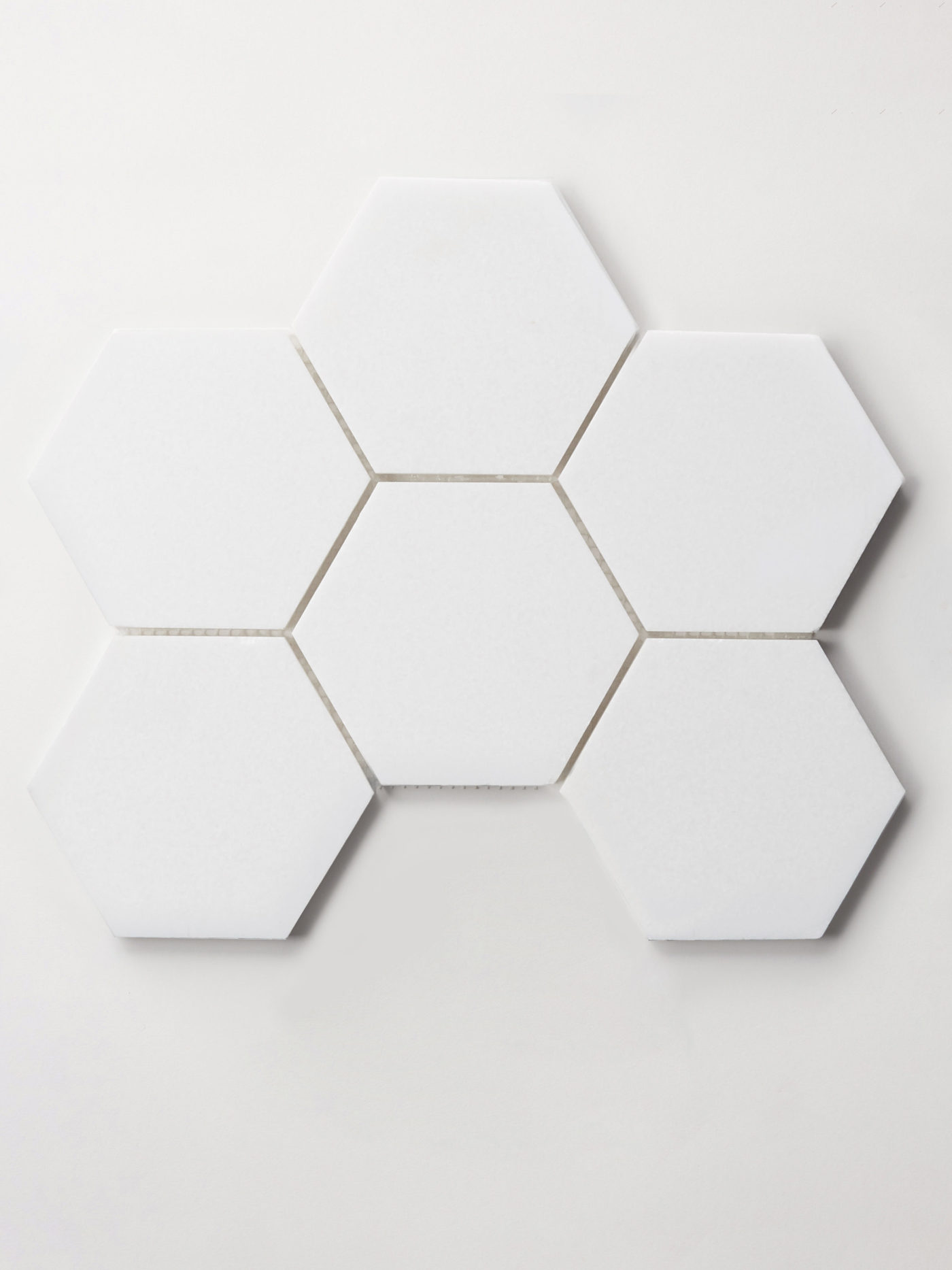 six white hexagon tiles on a white surface.